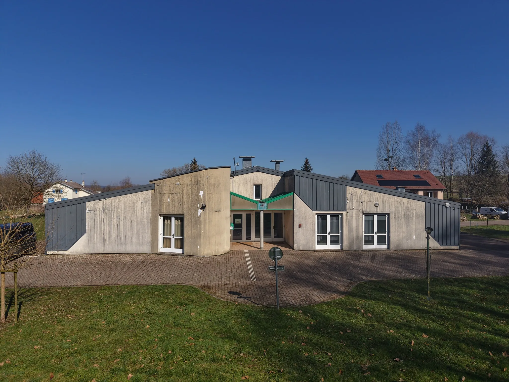 Bâtiment communal : bardage anthracite et béton
